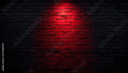 Dark brick wall background illuminated by a single red spotlight for design.