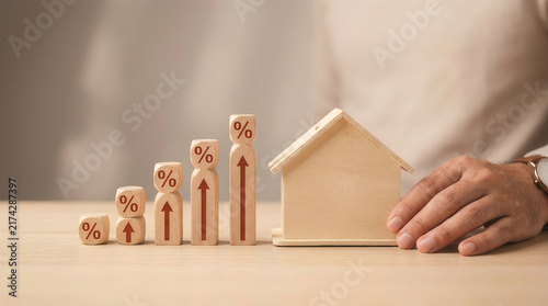 Wooden house model with rising percentage rate blocks chart