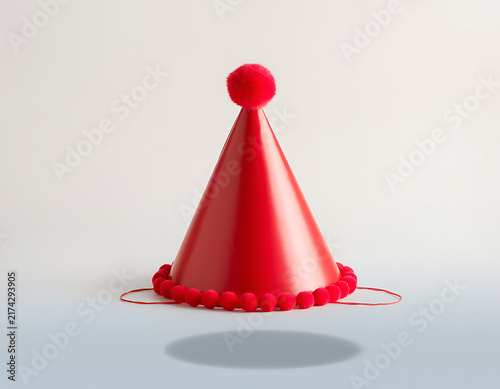 Red party hat with confetti on white