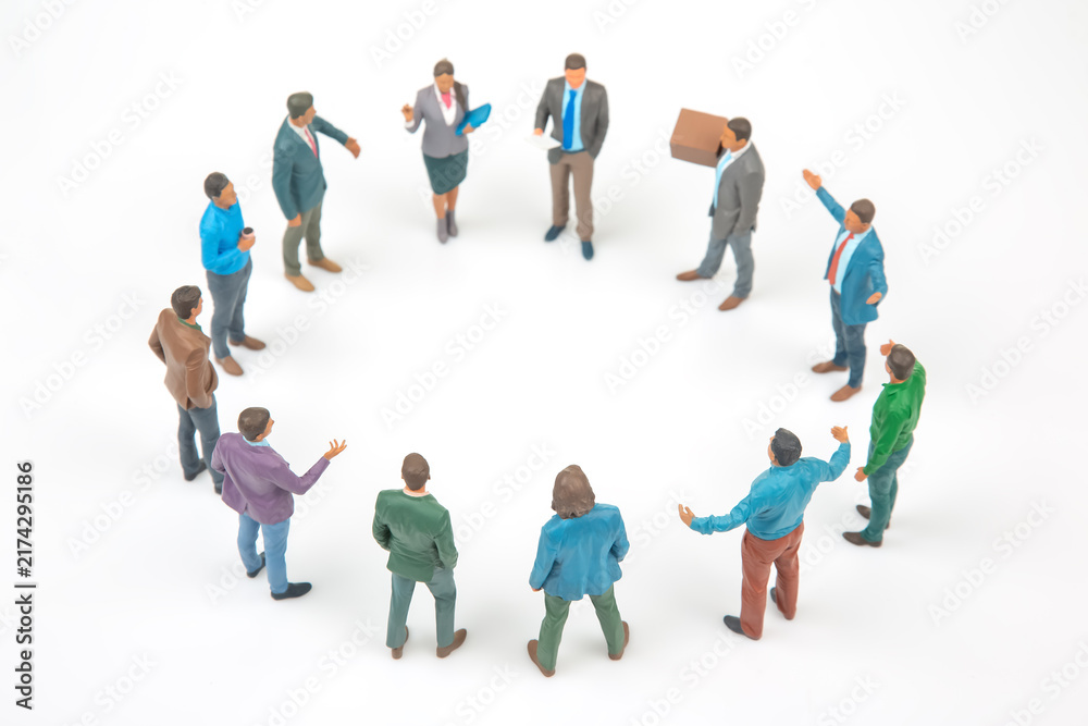 Fototapeta premium Miniature figures gather in a circle during a meeting in a simple setting