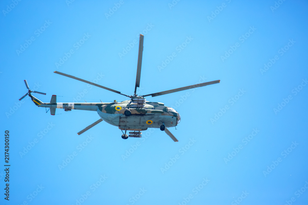 Fototapeta premium Helicopter flies in clear sky over open area during sunny day