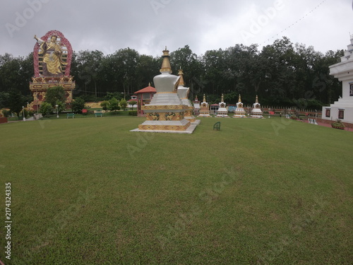 Obraz na plátne A peaceful outdoor view of a Buddhist monument or Buddha statue situated in a landscaped garden