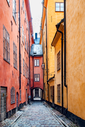 Картината върху платно A narrow cobbled street lined with brightly colored houses in the Gamla Stan (Old Town) district of Stockholm, Sweden