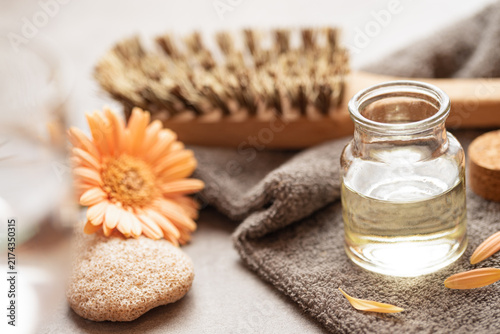 Nourishing body oil - glass bottle with oil, bath sponge, towel, and natural brush