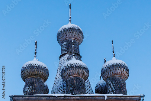 фотографія Front view of wooden lemesh cupolas and iron crosses of the historic Intercession Church in winter Zaostrovie, Arkhangelsk oblast, Russia