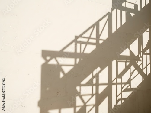 Architectural shadow of a staircase on a textured white wall abstract geometric pattern