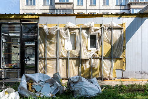 Repair work is being carried out outside the building. A lot of old materials and insulation can be seen