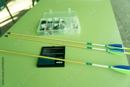 Photography Wooden arrows along with an electronic scale and a component box on a green tabl