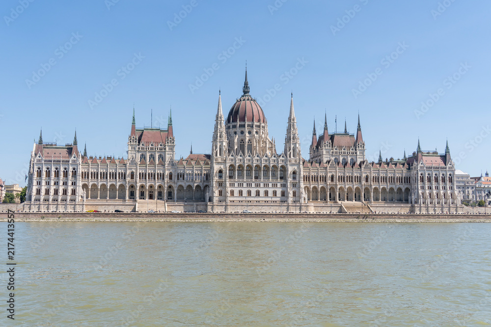 Obraz premium The neo-Gothic building of the Hungarian Parliament on the banks of the Danube in Budapest