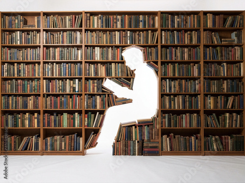 Cutout silhouette of person sitting and reading inside huge library bookshelf