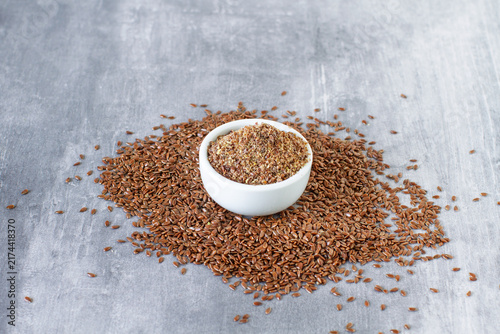 Flax dry seeds, whole and ground on a table