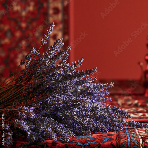 ultra sophisticated close up on lavender flowers, red arabic majlis background, editorial style