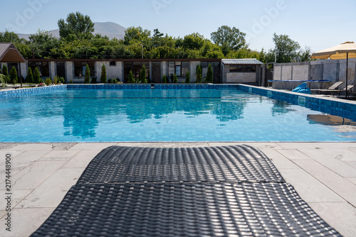 Luxury Outdoor Swimming Pool with Sun Loungers in Modern Resort.