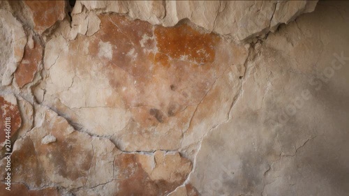 Close look at a cracked and weathered wall with faded colors and textures