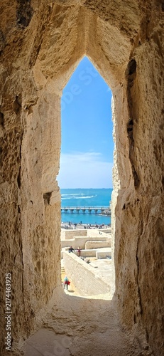View of the Mediterranean Sea through an ancient stone window in the Qaitbay Citadel, a 15th-century defensive fortress located on the Mediterranean coast, on Pharos Island in Alexandria, Egypt.