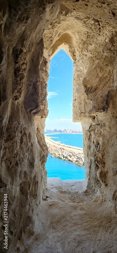 View of the Mediterranean Sea through an ancient stone window in the Qaitbay Citadel, a 15th-century defensive fortress located on the Mediterranean coast, on Pharos Island in Alexandria, Egypt.