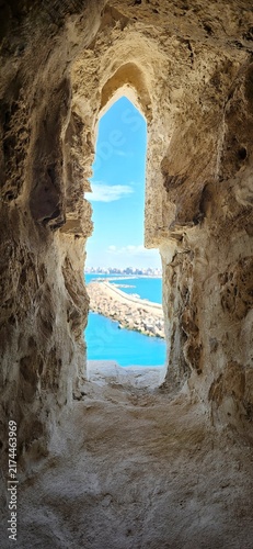 View of the Mediterranean Sea through an ancient stone window in the Qaitbay Citadel, a 15th-century defensive fortress located on the Mediterranean coast, on Pharos Island in Alexandria, Egypt.
