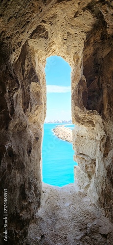 View of the Mediterranean Sea through an ancient stone window in the Qaitbay Citadel, a 15th-century defensive fortress located on the Mediterranean coast, on Pharos Island in Alexandria, Egypt.