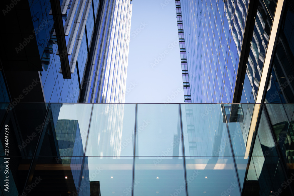 Obraz premium Modern Glass Skyscrapers Reflecting Blue Sky