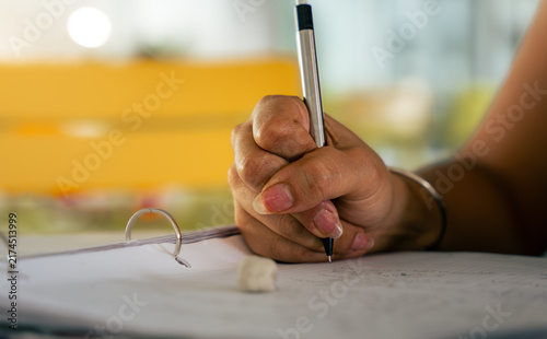 Fotografie Person writing notes in a binder with pen