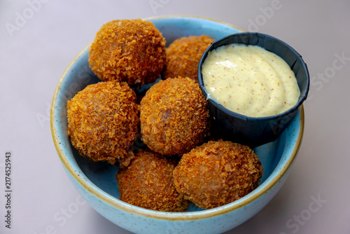 Bitterballen, Dutch meat-based snack in white plate served with mustard on wooden tabel background, Typically containing a mixture of beef or veal, Bitterballen are one of Holland's favorite snacks.