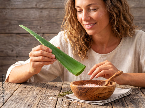 Portrait of healthy young model girl holding fresh green aloe vera leaf for skincare