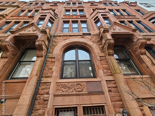 Konstfotografi Brownstone building facade with arched window and carved stone details