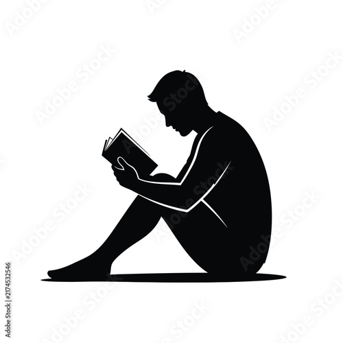 Man sits on the ground with his legs bent and reads an open book.