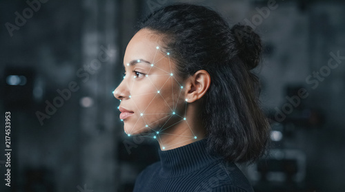 Facial Recognition Technology: A profile view of a young woman with her face highlighted by digital markers, showcasing advanced biometric identification system for security and authentication.