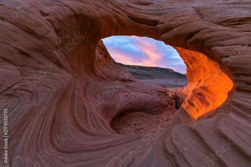Ethereal glow illuminates textured sandstone arch at dawn
