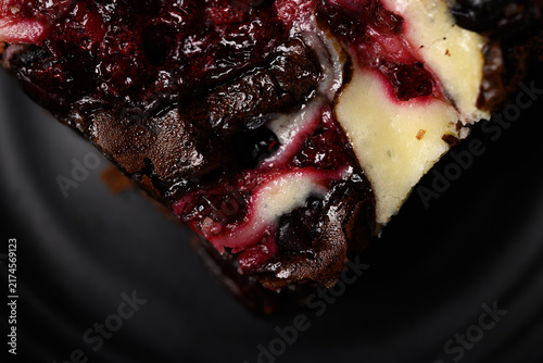 Close-up of delicious homemade cranberry cream cheese brownies on a dark background