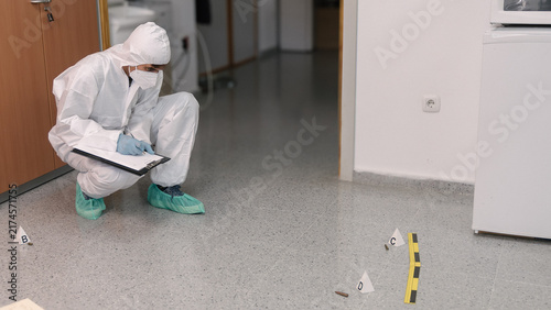 Konstfotografi Forensic investigator recording marked ammunition evidence indoors
