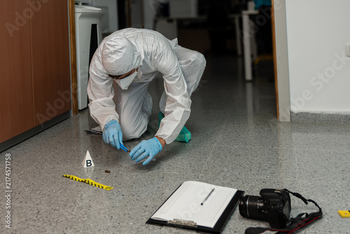 Cuadro en lienzo Forensic investigator securing evidence with camera and clipboard nearby