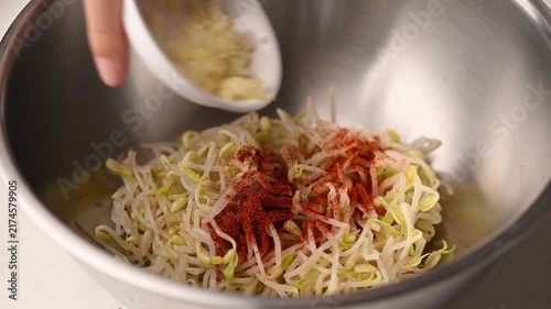 Preparing Korean bean sprouts salad (Kongnamul Muchim) in a mixing bowl