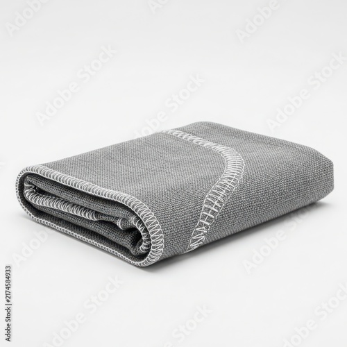 Folded grey textured blanket with fringe detail on white background