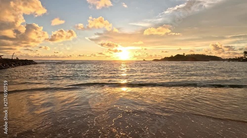 Wide shot capturing a beautiful sunset over the Indian Ocean in Sri Lanka, featuring cliffs and the sun's reflection on the sea at nighttime.