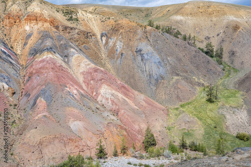 A beautiful mountain landscape with colorful slopes and trees.