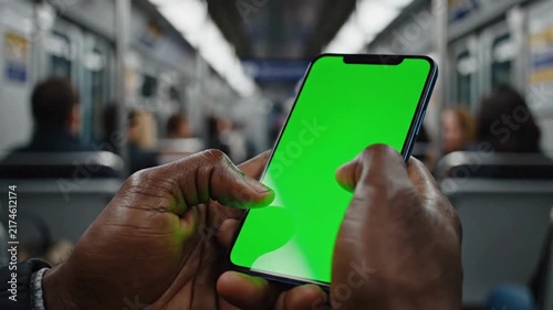 Night Metro Technology, A moody urban subway scene centered on a smartphone displaying a vivid green screen, with subtle reflections and motion in the surrounding train interior.