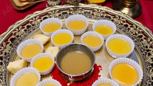 Traditional brass tray with fifty six yellow rice cakes with evoking cultural ritual ambiance paper