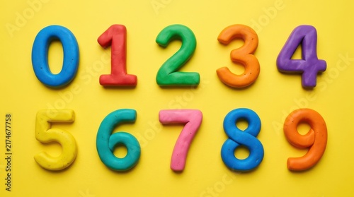 Colorful numbers from zero to nine made of clay on a yellow background