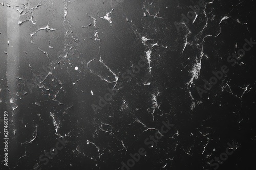dark scratched surface with scattered white flecks, peeling marks and moody high-contrast gritty texture