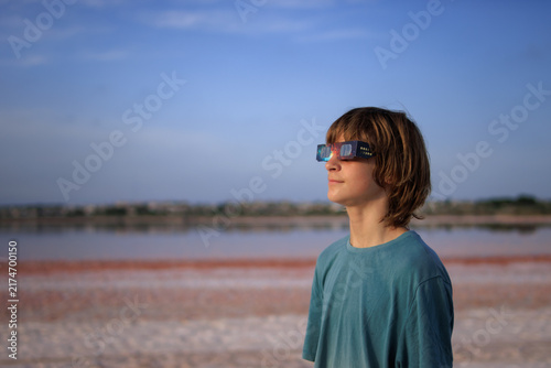 Canvastavla Young boy wearing special eclipse glasses safely observing a solar eclipse outdo