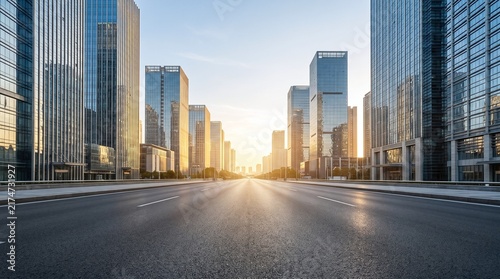 A modern city street lined with tall glass skyscrapers at sunrise urban
