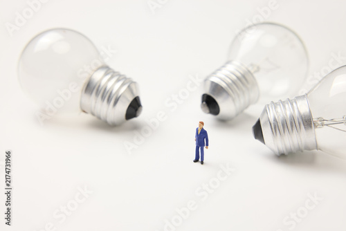 Businessman Standing Among Light Bulbs Representing Ideas and Innovation