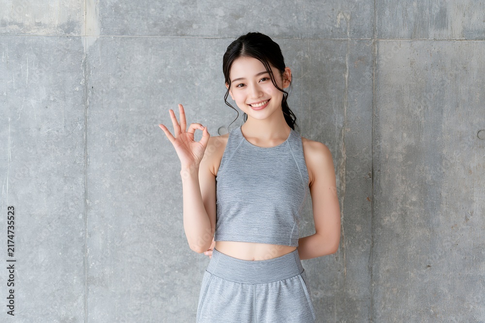 Fototapeta premium 笑顔でOKサインする日本人女性ヘルシーなフィットネス姿