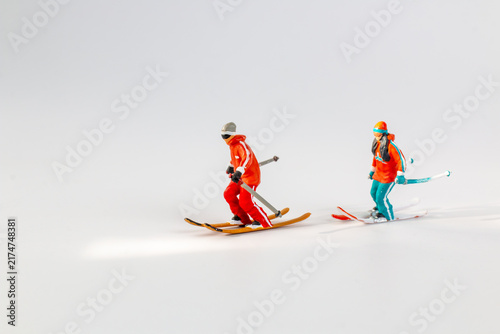 Miniature Figurines of Skiers on White Background