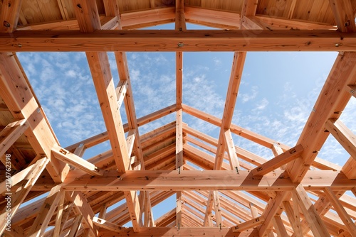 Obraz na płótnie 木造住宅建築現場で新しい家を建てる木材の骨組みと青空