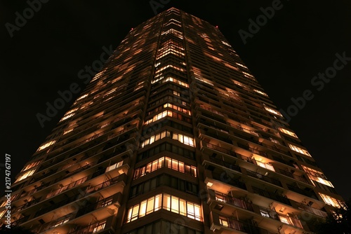 Obraz na płótnie 都会の夜空にそびえる高層マンションから漏れる温かい明かり