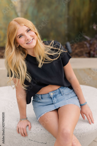 Young blonde woman with blue eyes smiling outdoors