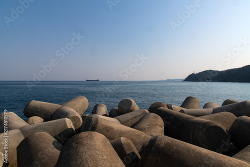 Canvastavla Concrete Tetrapod Breakwater with Cargo Ship on Ocean Horizon